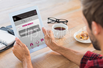 Composite image of rear view of man using tablet on wooden table