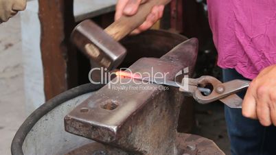 blacksmiths forges a horseshoe