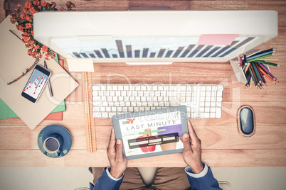 Composite image of businessman holding digital tablet while sitt