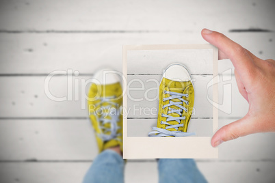 Composite image of hand holding polaroid picture