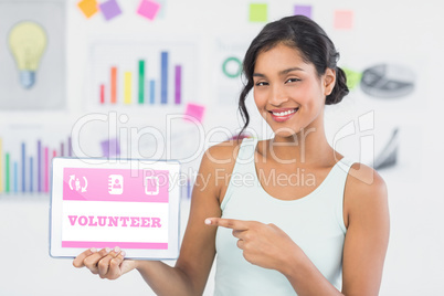 Composite image of smiling businesswoman pointing at digital tab