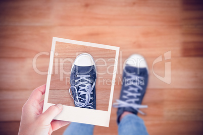 Composite image of hand holding polaroid picture