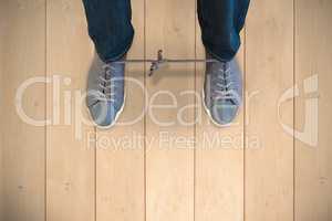 Composite image of man with shoelaces tied together