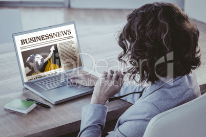 Composite image of businesswoman using laptop at desk in creativ