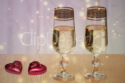 Two wine glasses filled with champagne, and candles.