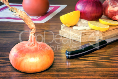 The still life: large onion and lemon on the table.