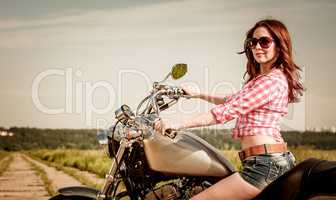 Biker girl sitting on motorcycle