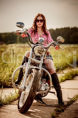 Biker girl sitting on motorcycle