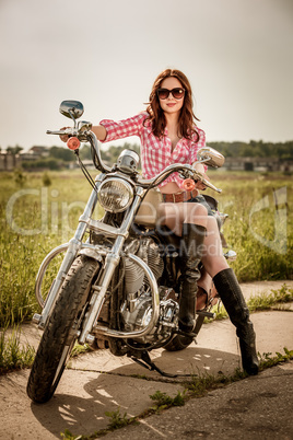 Biker girl sitting on motorcycle