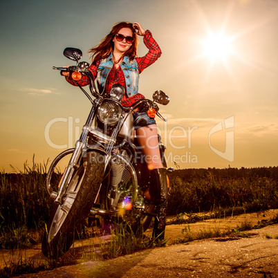 Biker girl sitting on motorcycle