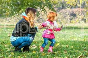 Mom plays with her daughter in the park