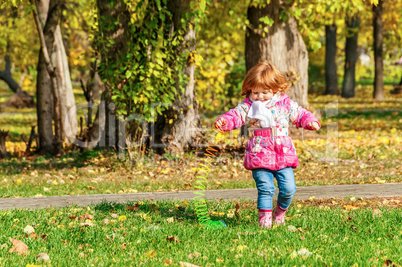 Girl playing in the park with a Rainbow spiral spring