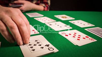 Close up of female hands holding cards and playing solitaire