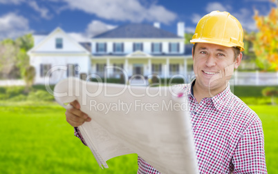 Contractor Holding Blueprints In Front of  Beautiful Custom Home