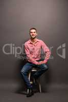 Handsome man sitting on a chair in studio