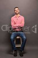 Handsome man sitting on a chair in studio