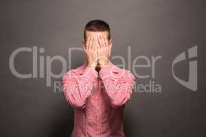 Man covering eyes his face