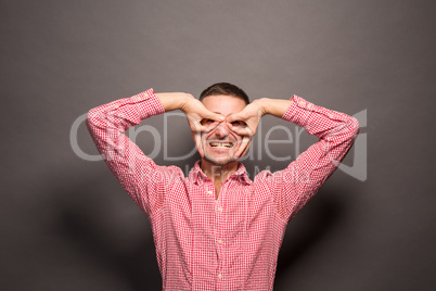 Man looking through his fingers