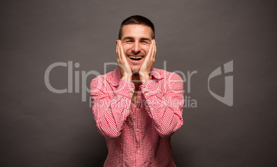 Young man holding his ckeeks