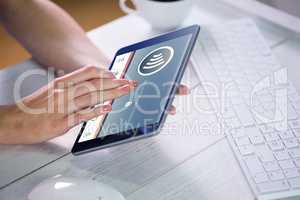 Composite image of woman using tablet at work