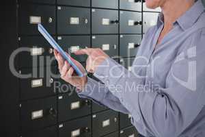 Composite image of businesswoman using her tablet