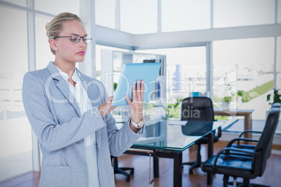 Composite image of businesswoman using digital tablet