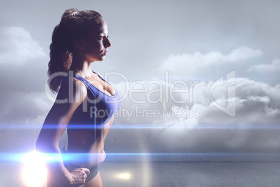 Composite image of side view of sexy athlete with hands on hip