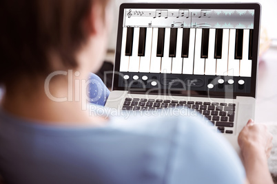 Composite image of pregnant woman using her laptop