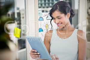 Composite image of smiling businesswoman using digital tablet