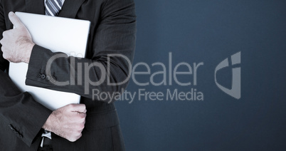 Composite image of businessman holding his laptop tightly