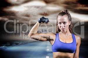 Composite image of portrait of confident woman flexing muscles