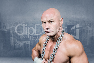 Composite image of portrait of confident fighter holding chain