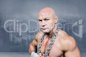 Composite image of portrait of confident fighter holding chain