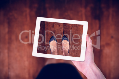 Composite image of feminine hand holding tablet