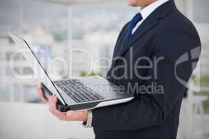 Composite image of businessman with watch using tablet pc