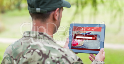 Composite image of army man using tablet