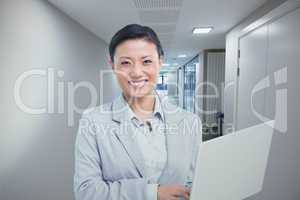 Composite image of businesswoman using laptop with colleagues be