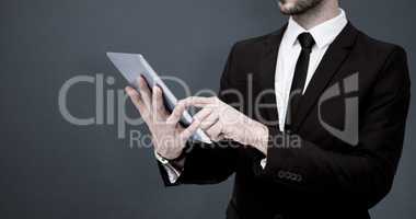 Composite image of mid section of a businessman using digital ta