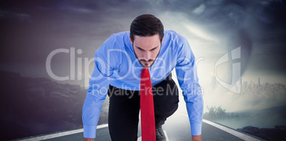 Composite image of focused businessman ready to race