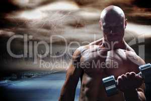 Composite image of concentrated bodybuilder lifting dumbbell