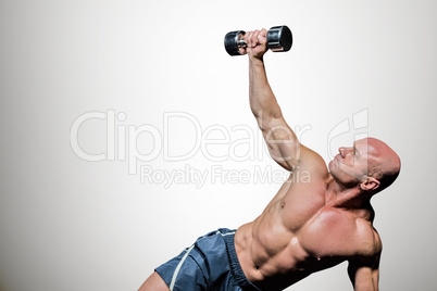 Composite image of man exercising with dumbbells