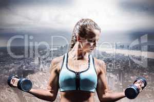 Composite image of sporty woman lifting dumbbells