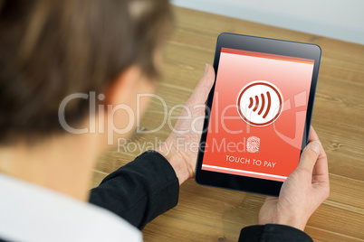 Composite image of businesswoman using tablet at desk