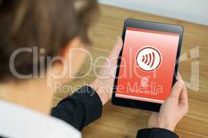 Composite image of businesswoman using tablet at desk