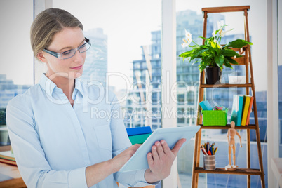 Composite image of businesswoman using tablet pc