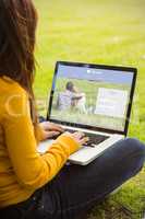 Composite image of woman using laptop in park