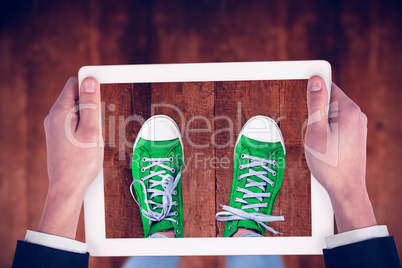 Composite image of feminine hands holding tablet