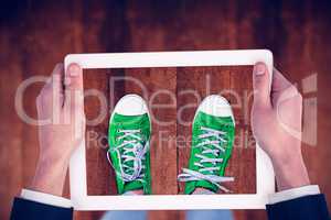 Composite image of feminine hands holding tablet