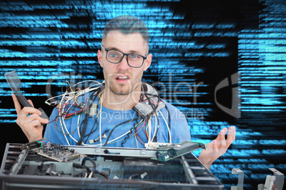 Composite image of confused it professional with cables and phon