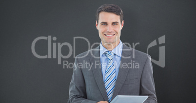 Composite image of businessman using a tablet  with colleagues b